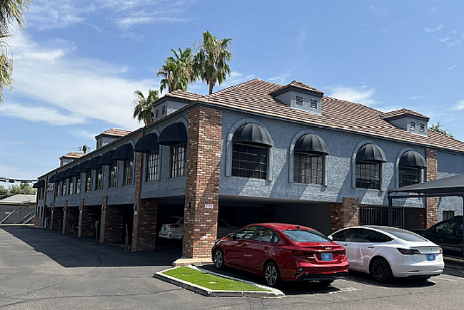 Exterior of our office building in Phoenix, with a red car and white car parked in front.